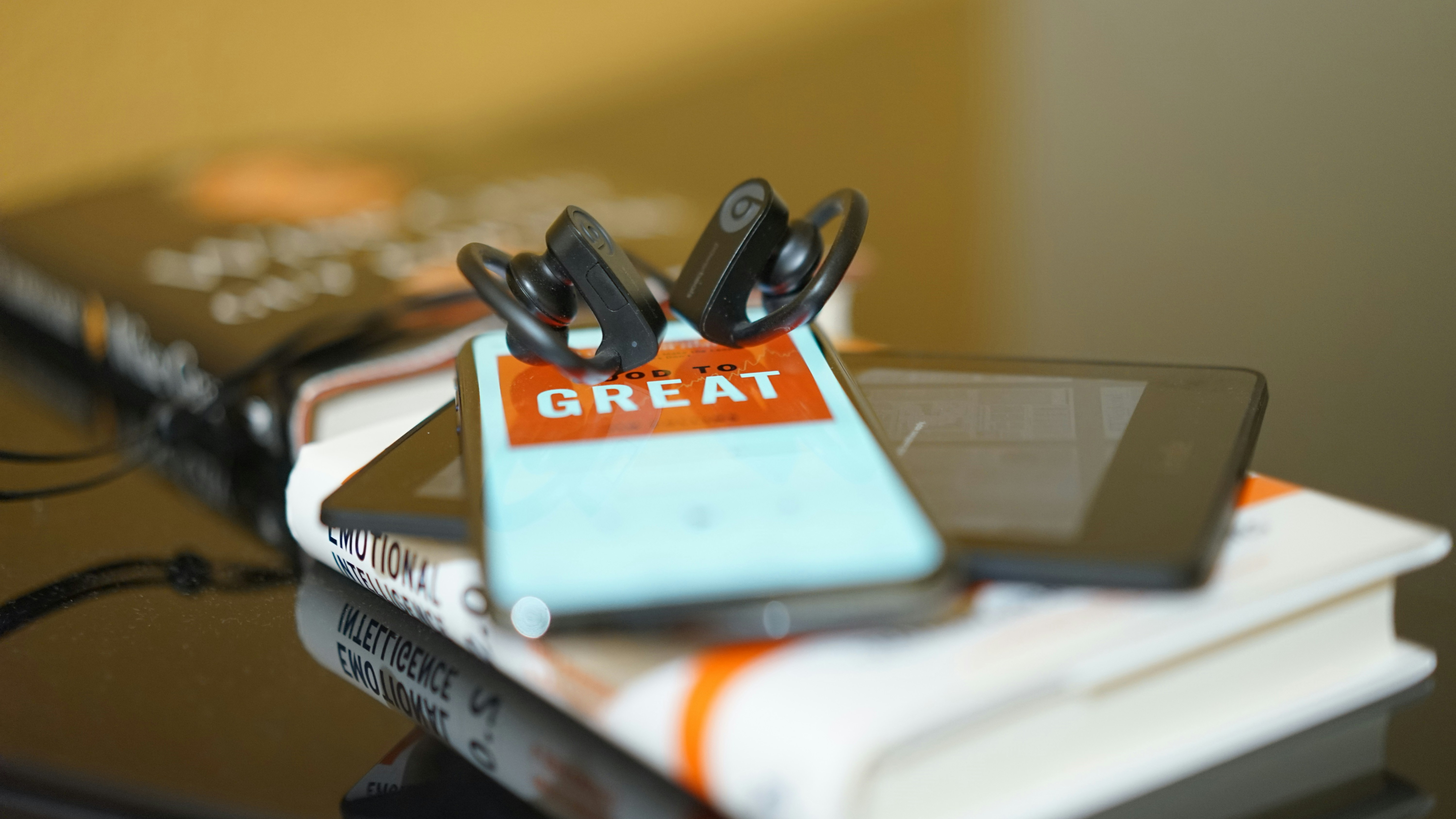 Earbuds, books, and a cellphone playing an audiobook