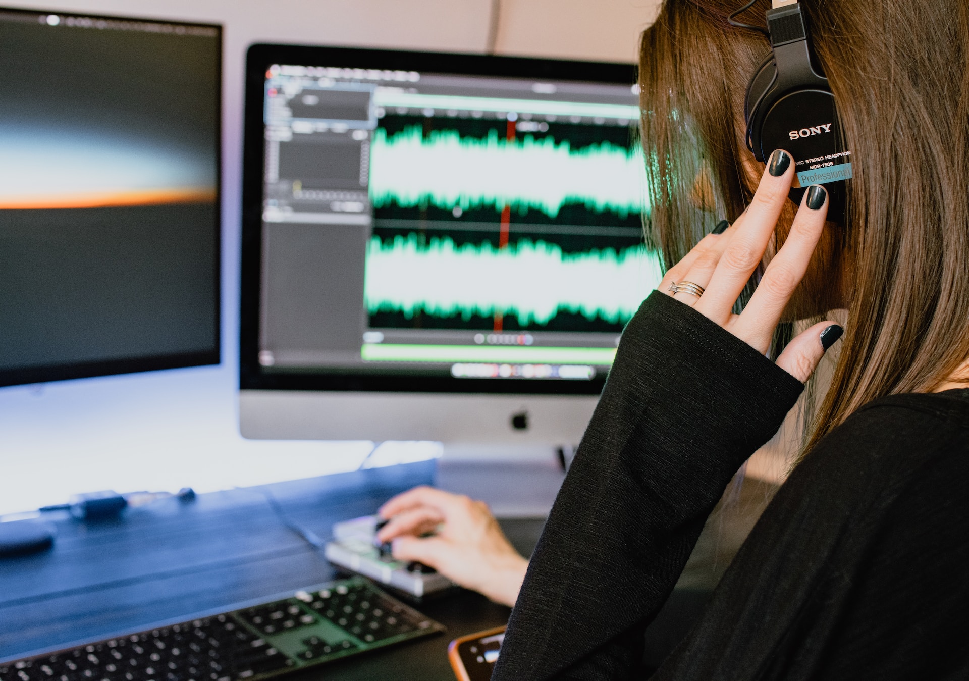 Woman wearing headphones and using a video editing software