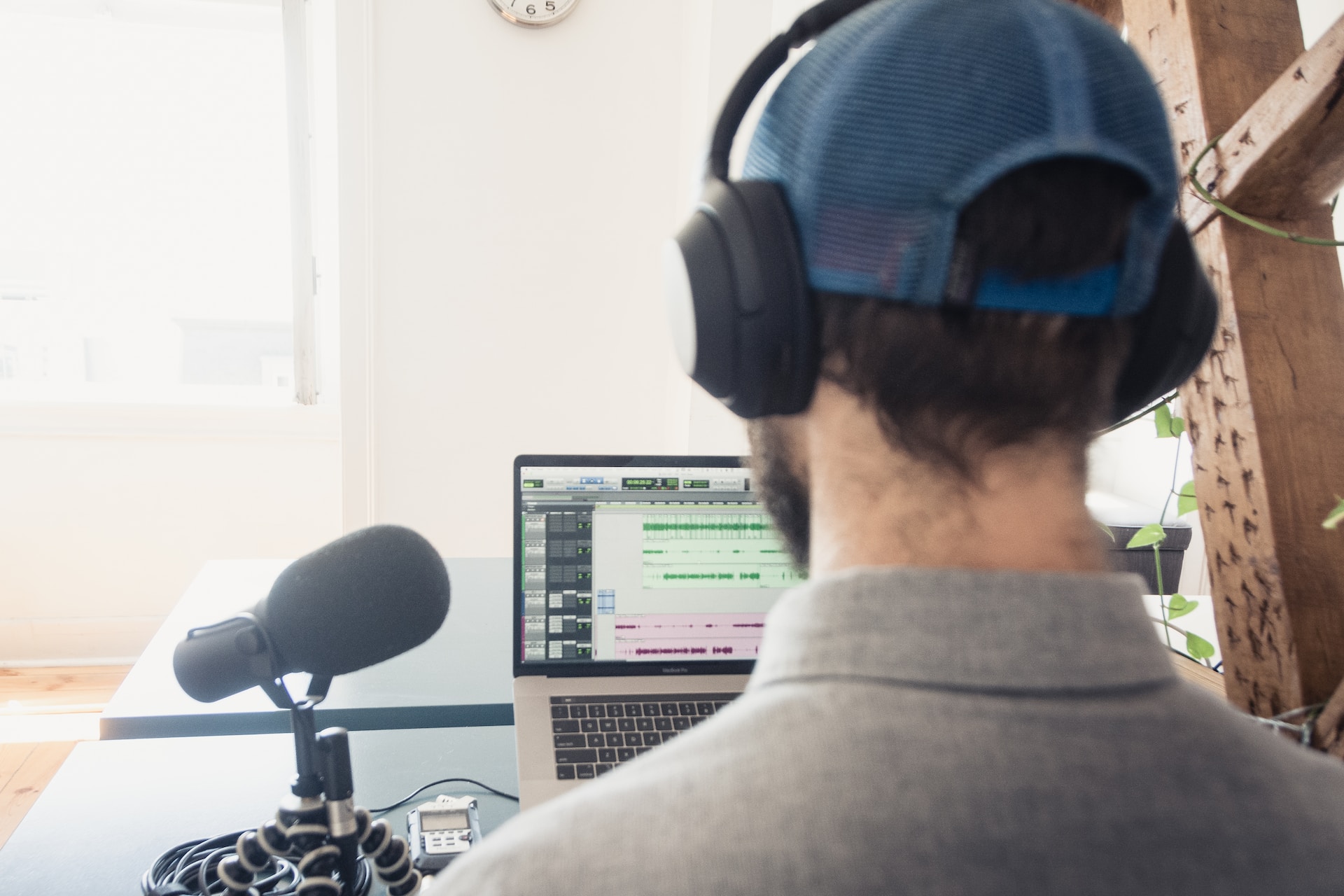 View of a laptop and microphone from behind a man’s head