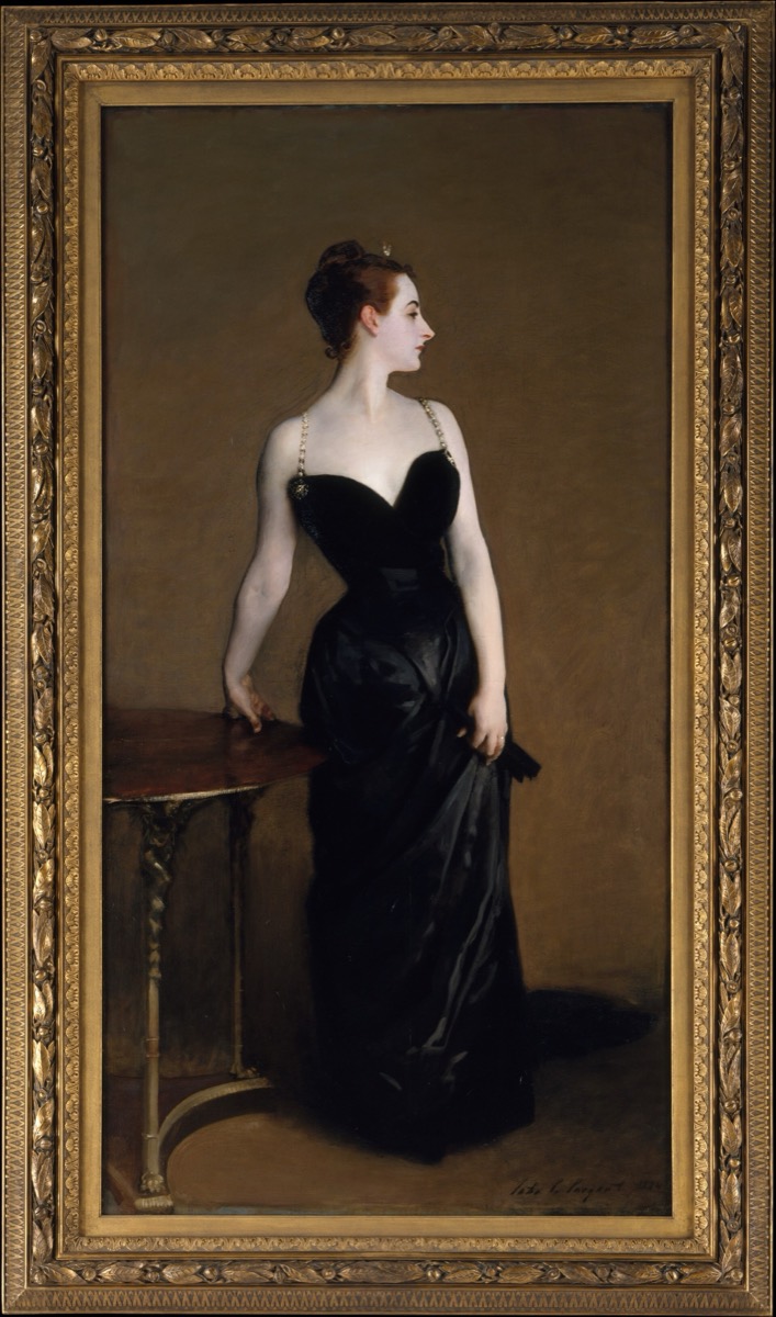 Portrait of a pale woman in a black gown in a gilded frame
